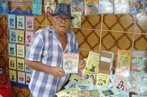 José Costa Leite expondo suas produções/Cordel «Lampião fazendo o diabo chocar um ovo»